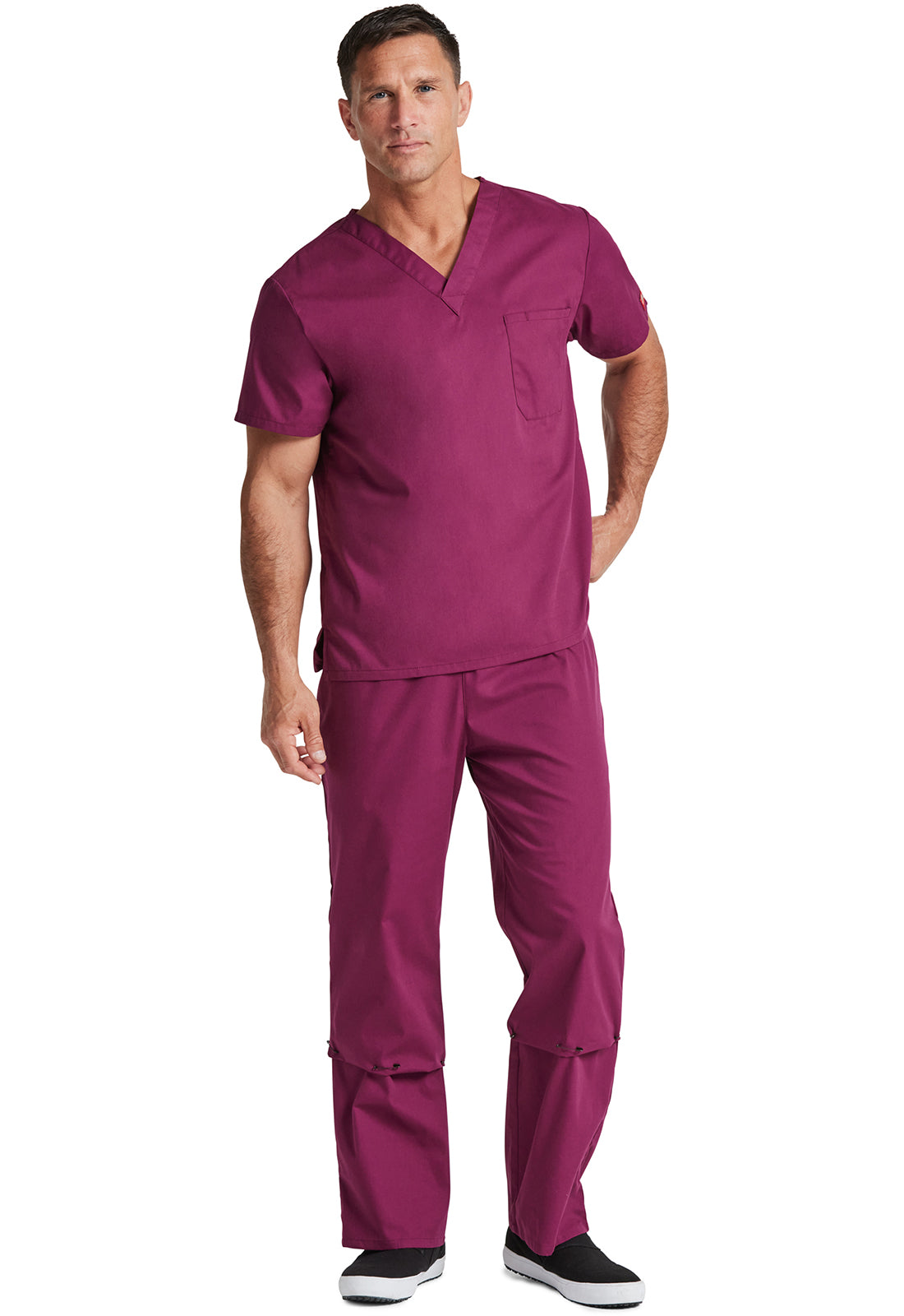 Unisex top met V-hals die in de broek gedragen kan worden met borstzak en zijsplitten